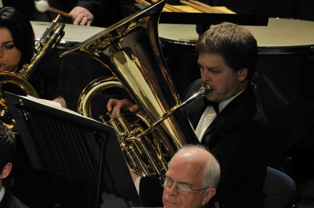 Nicholas playing a tuba in an orchestra.